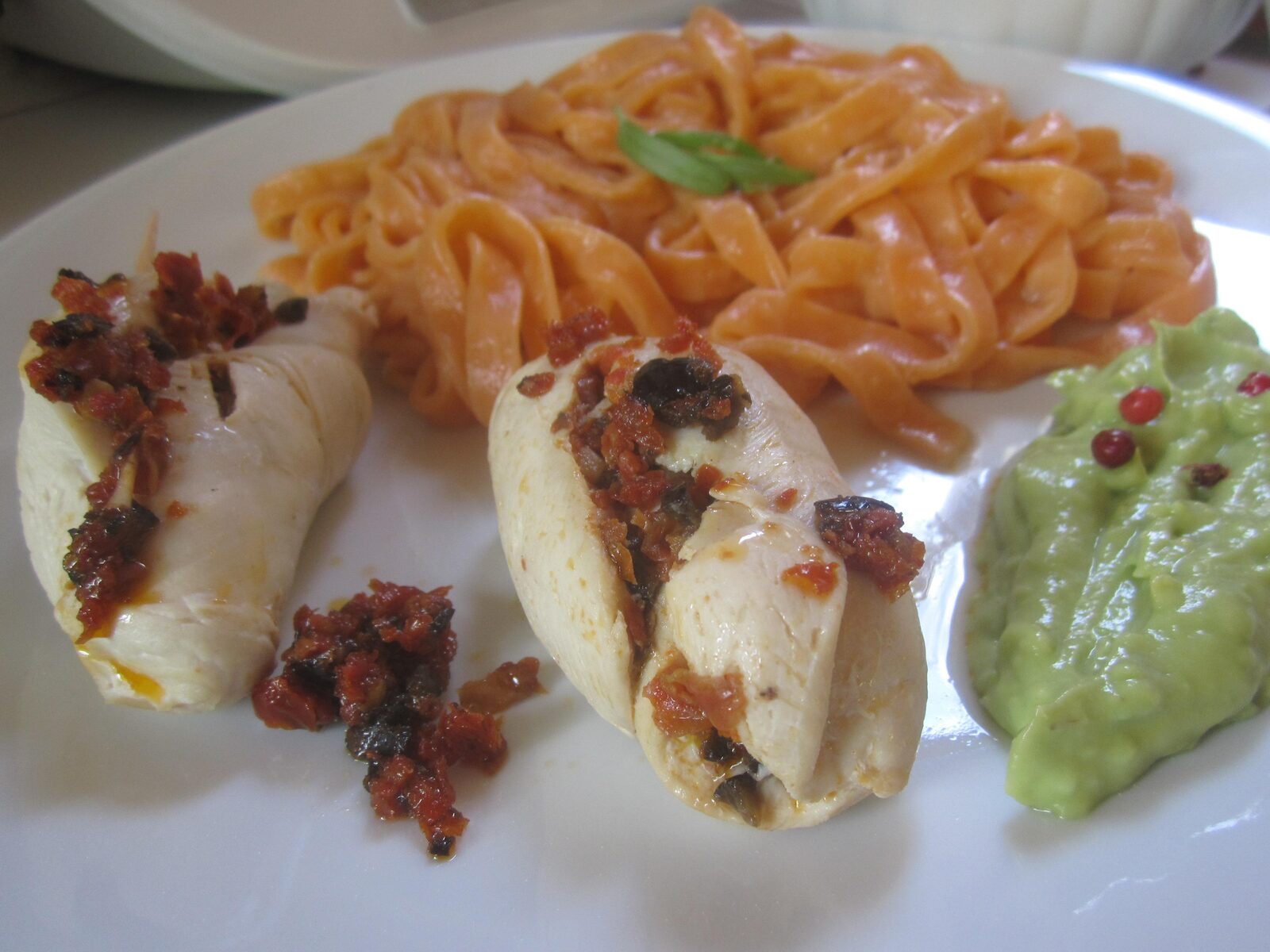 Ballotins de volaille, aux tomates séchées et olives noires, pâtes fraîches rouges et sauce crémeuse à l'avocat