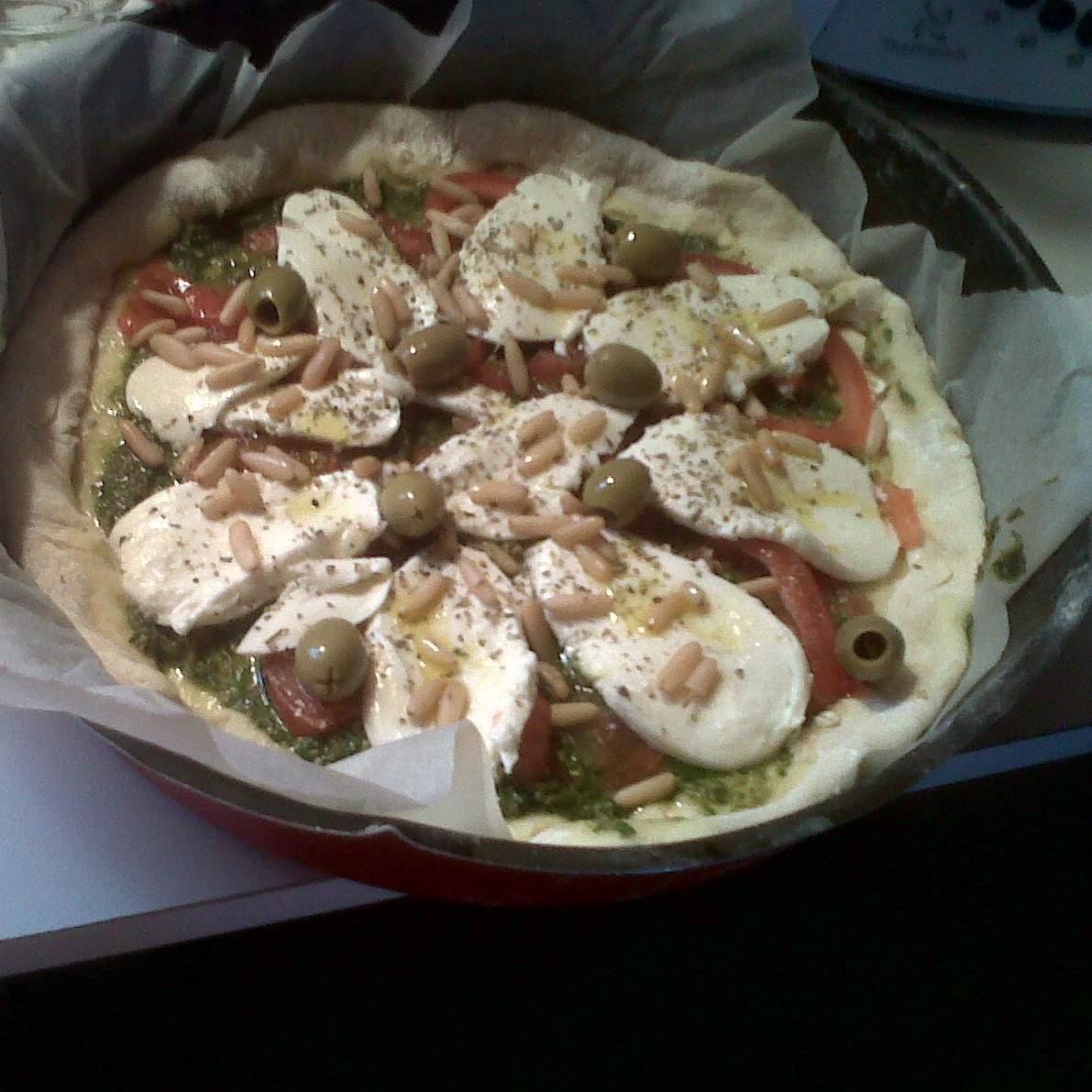 pizza sur fond de pistou tomate mozza aux pignons