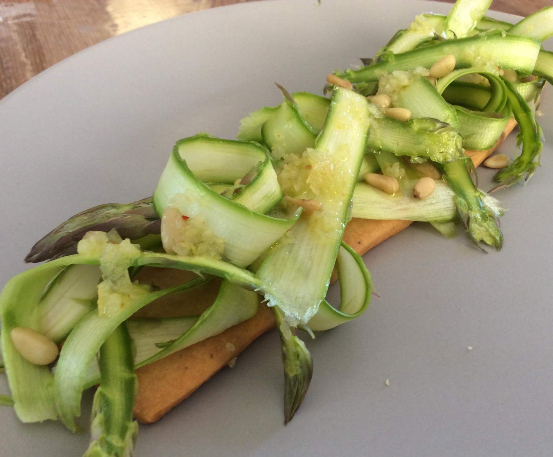 Salade d'asperges vertes, vinaigrette au citron confit, sur sablé au Comté